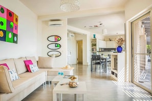 A modern living room with a sofa, coffee table, and artwork on the wall.