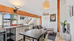 Eine moderne Küche mit Essbereich, Holzbalken und Deckenventilator.