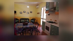 Une cuisine compacte avec un coin repas, comprenant une cuisinière, des placards et une table avec des chaises.