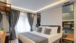 A modern hotel room with a large bed, bedside tables, a desk, and a mirror. - Depiero Hotel Karaköy (Istanbul)