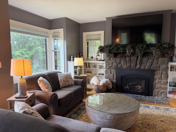 A living room with a fireplace, a sofa, a coffee table, and a lamp.