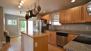 A kitchen with wooden cabinets, a stainless steel refrigerator, and a granite countertop. - Phenomenal location in Bath, ME- Comfortable,3 BR, 2 bath, Close to Everything! (Bath)
