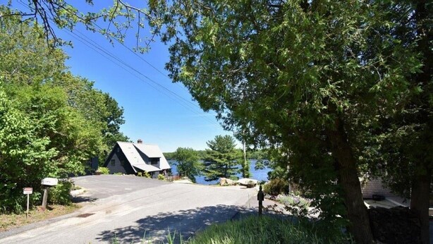A house with a sloped roof, a driveway, and a body of water in the background. - Phenomenal location in Bath, ME- Comfortable,3 BR, 2 bath, Close to Everything! (Bath)
