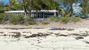 A beachfront property with a white building surrounded by trees and vegetation. - Beautiful House on the beach. Come and enjoy your paradise vacation! (George Town)