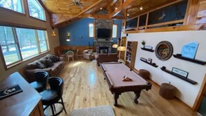 Amplia sala de estar con mesa de billar, asientos cómodos y zona de bar.