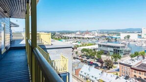 Un balcón con vistas a un puerto deportivo y al paisaje urbano.