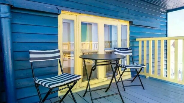 A blue wooden deck with a table and two chairs. - Unique and Sunny Top Floor Old Quebec Gem (Quebec City)