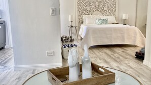 Ein Schlafzimmer mit Bett, Nachttischlampen, Deckenventilator und einer dekorativen Wandverkleidung.
