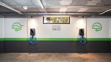 Un parcheggio con due stazioni di ricarica per veicoli elettrici, ognuna contrassegnata da un numero e un'icona verde.