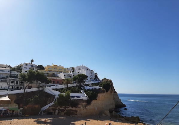 A coastal town with buildings on a cliff overlooking the sea.