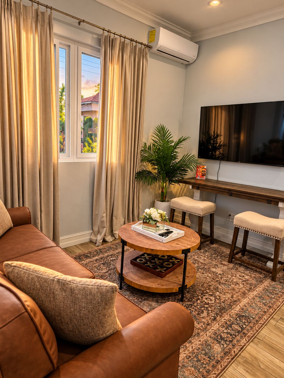 A living room with a sofa, a coffee table, a TV, and a window with curtains.