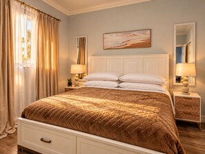 Een slaapkamer met een groot bed, twee nachtkastjes, een spiegel en een schilderij aan de muur.