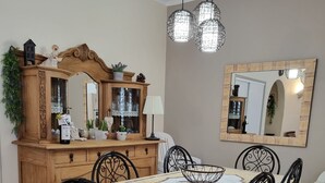 Un comedor con un aparador de madera, un espejo y una araña.
