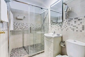 A bathroom with a glass-enclosed shower, a white sink, and a tiled backsplash. - Family, cozy 2 bedroom apartment (Carvoeiro)