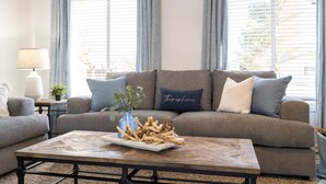 A living room with a grey sofa, a coffee table with a decorative centerpiece, and a lamp on a side table. - Old Town Scottsdale | Heated Pool & Putting Green (Scottsdale)