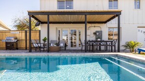 A pool area with a covered patio, outdoor furniture, and a grill. - Old Town Scottsdale | Heated Pool & Putting Green (Scottsdale)