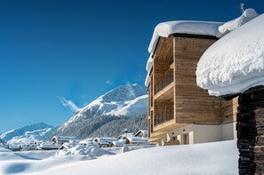A wooden building with a balcony, surrounded by snow-covered houses and mountains. - Vetta Alpine Relax (Livigno)