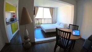 Une chambre d’hôtel avec un lit, un bureau avec un ordinateur portable, une lampe et une vue sur le balcon.
