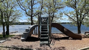 A playground with a slide and stairs, surrounded by trees and a lake. - Stately home by Spirit Lake in Menahga (Menahga)