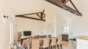 Eine moderne Küche mit Essbereich, Holzbalken und einem großen Fenster.