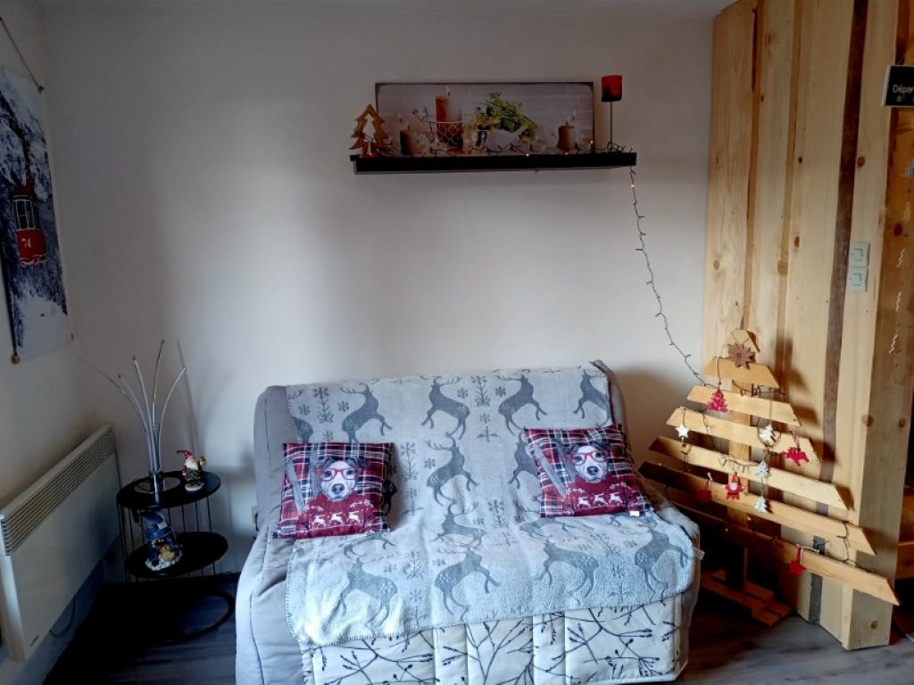 Una stanza accogliente con un divano, un tavolino e una mensola in legno decorata.