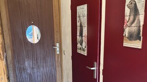 A wooden door with a circular mirror and a doormat with "I ♥ M" on it.