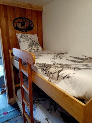 Ein Stockbett mit einem Holz-Kopfteil und einer Wanddekoration.