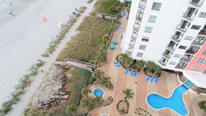 A resort with multiple swimming pools, a beach area, and a multi-story building with balconies.