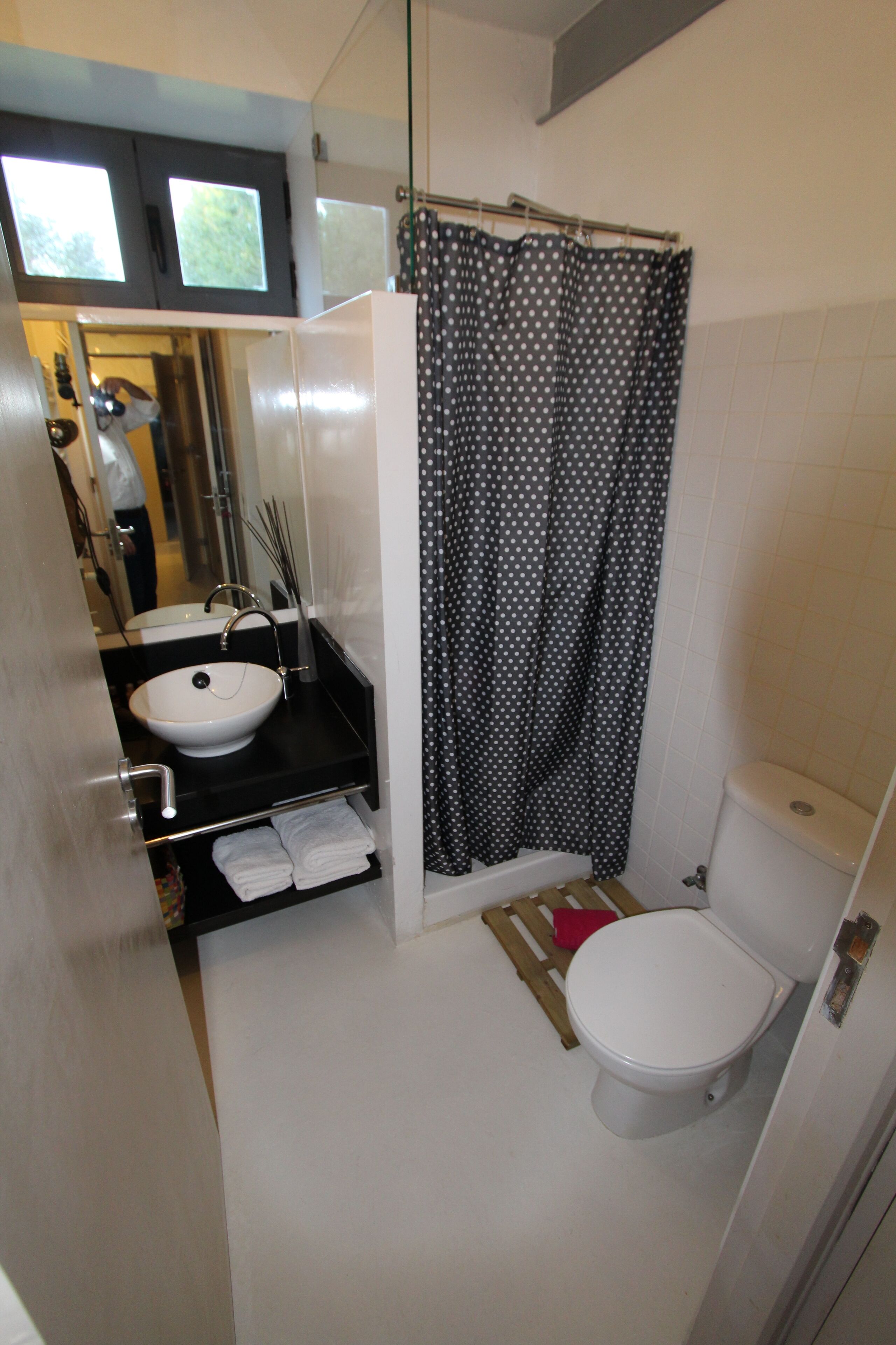 Une petite salle de bain avec un lavabo blanc, des toilettes et un rideau de douche.