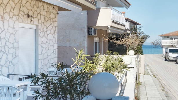 Un edificio costero con balcones, fachada de piedra y vista al mar.