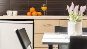 Una cocina moderna con encimera, un vaso de jugo de naranja y una planta en maceta.