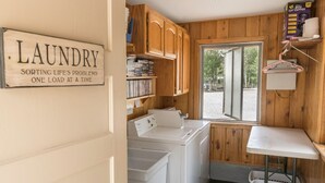 A laundry room with a washing machine, dryer, and a sign that reads "LAUNDRY SORTING LIFE'S PROBLEMS ONE LOAD AT A TIME". - Willow Springs Resort (Bridgeport)