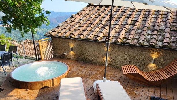 A wooden deck with a hot tub, two lounge chairs, and a tiled roof. - Casa Melograno.  3 bedrooms, 2 bathrooms, Spa-pool, patio, sea &  valley views (Gombitelli)