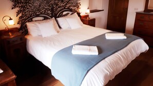 A neatly made bed with a blue blanket and two towels, a wooden headboard, bedside lamps, and a wooden dresser. - Casa Melograno.  3 bedrooms, 2 bathrooms, Spa-pool, patio, sea &  valley views (Gombitelli)