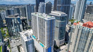 A high-rise building with multiple floors, a swimming pool on the rooftop, and a view of the surrounding cityscape. - Fabulous Two Bedrooms Brickell+ Free Parking (Miami)