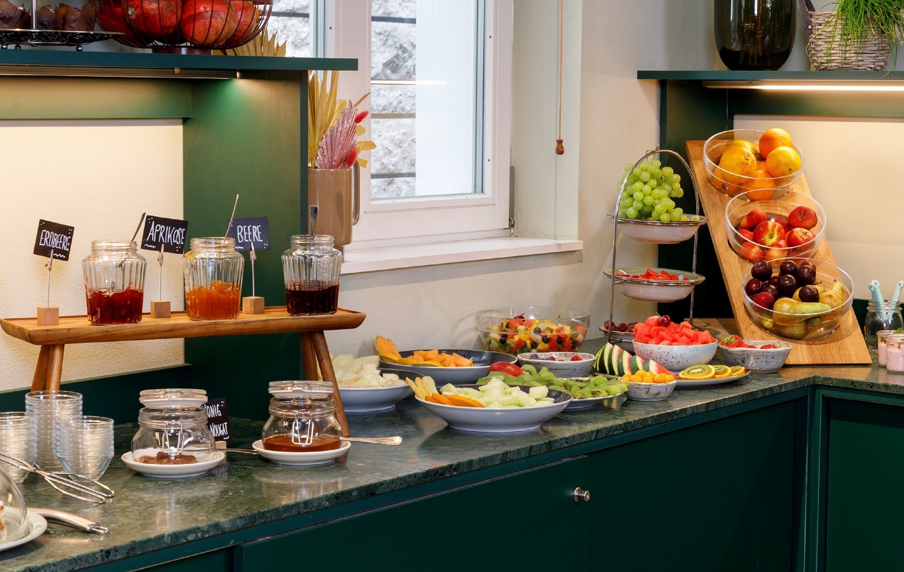 Un bufé con diversas frutas, verduras y bebidas.