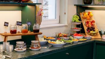 Un bufé con diversas frutas, verduras y bebidas.