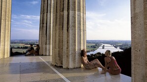 A stone structure with columns and a view of a river and landscape. - Hotel Das Regensburg (Regensburg)
