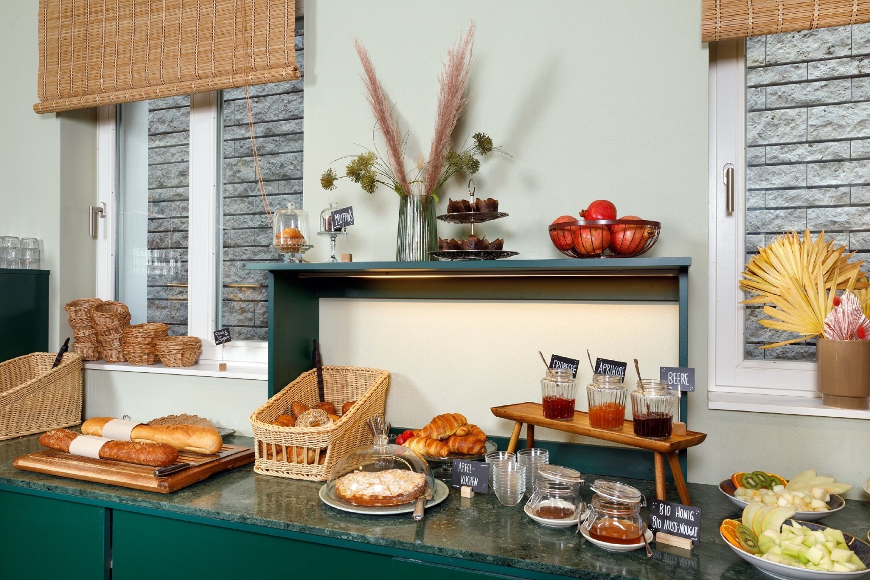 A breakfast buffet with various pastries, fruits, and beverages.