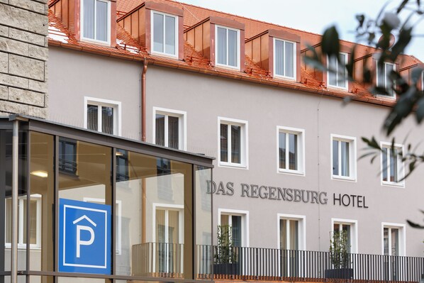 A building with a sign reading "Das Regentsburg Hotel" and a blue parking sign. - Hotel Das Regensburg (Regensburg)