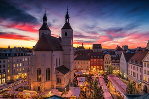 A historic town square with a prominent church, market stalls, and traditional buildings. - Hotel Das Regensburg (Regensburg)