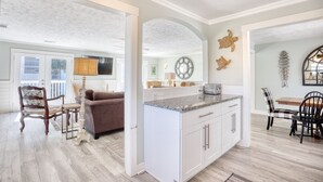 A spacious living area with a large window, a fireplace, and a dining area with a table and chairs. - O-Sea-D | Second-row | Private Heated Pool (North Myrtle Beach)