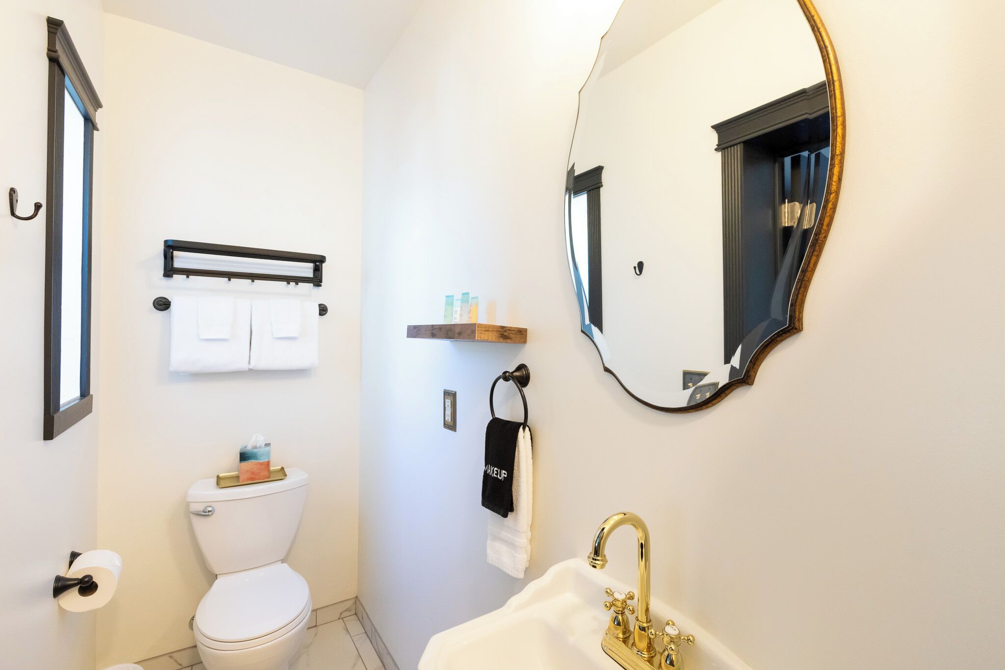 A bathroom with a toilet, sink, and mirror.