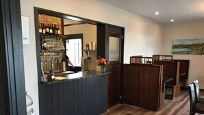 A restaurant with a bar area, wooden booths, and a kitchen sign. - Hotel Stevenson (Stevenson)