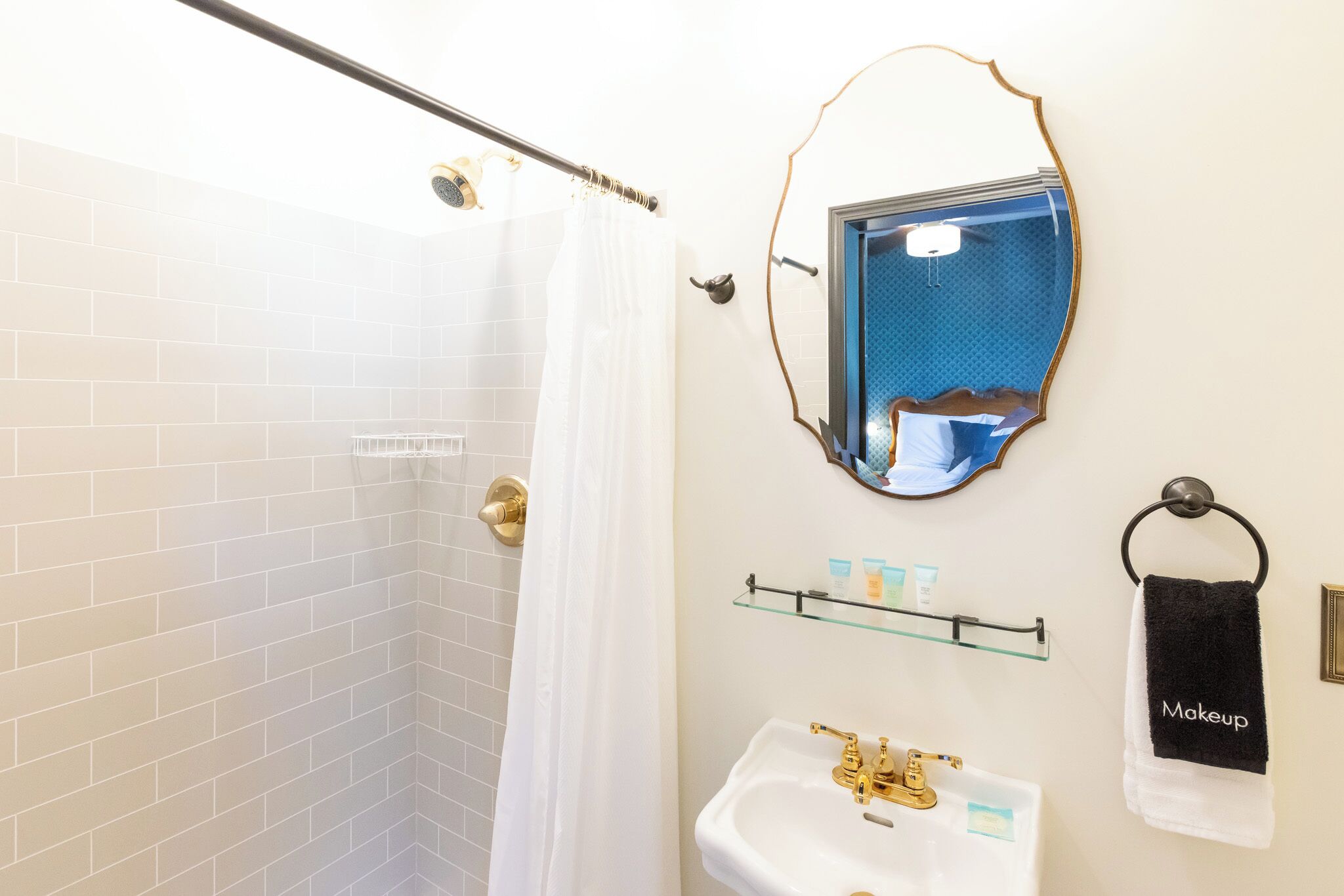 Un baño con ducha, lavamanos y espejo.