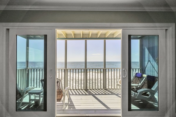 Screened patio with outdoor seating and views of the Gulf