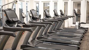 A row of treadmills in a gym with large windows in the background. - Upscale Family-Friendly Beachfront Condo Conveniently Located (Gulf Shores)