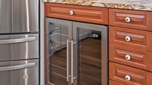 Una cocina con electrodomésticos de acero inoxidable, horno empotrado y armarios de madera.