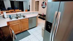 A modern kitchen with stainless steel appliances, wooden cabinets, and a central island.