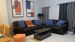 A living room with two sofas, a coffee table, and a dining table.